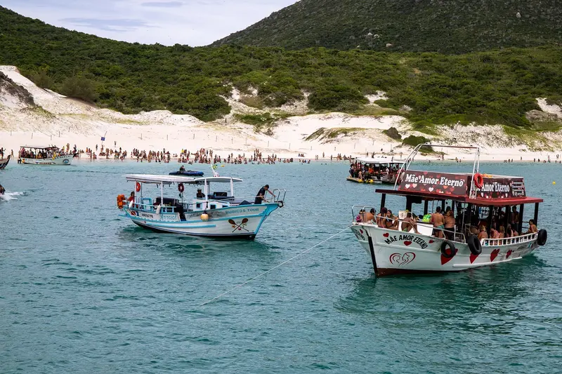 Barcos de passeio cheios de turistas em Arraial do Cabo